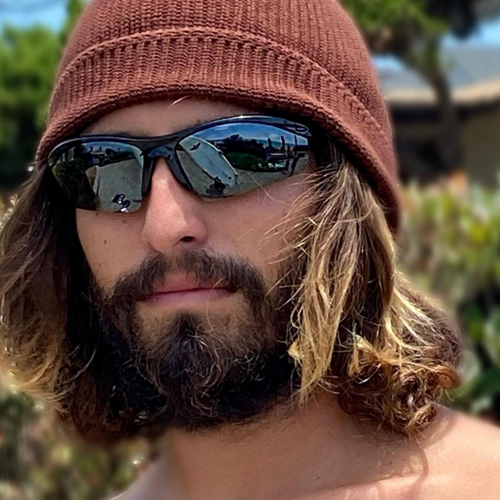 Bearded man in brown knit hat wearing Sea Striker Captain's Choice polarized sunglasses in black frame with silver mirrored lenses