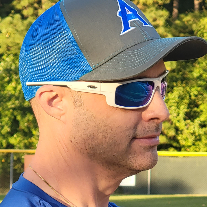 Man wearing baseball cap and Sea Striker Finatic polarized sunglasses in white frame with blue mirrored lenses