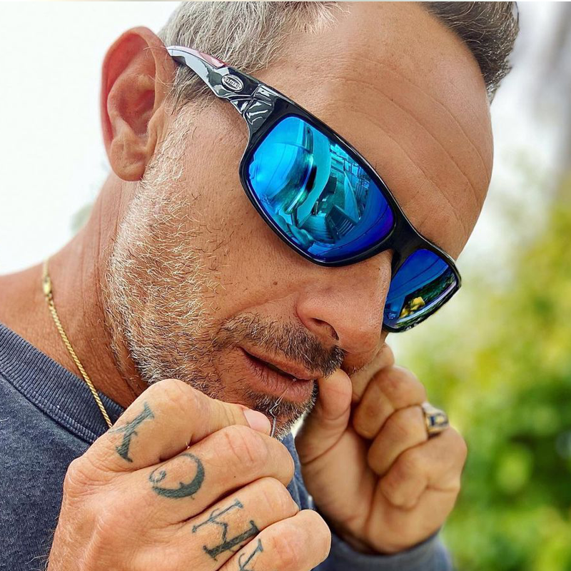 Man with AHOY finger tattoos wearing Sea Striker Gulfstream polarized sunglasses in black frame with blue mirrored lenses