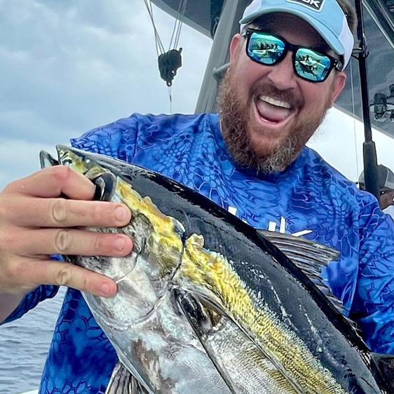 Man wearing Sea Striker sunglasses holding large fish