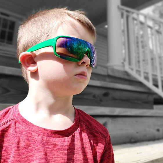 Young boy wearing Just A Shade Smaller® Boys Flash Shield Sunglasses in green frame with green mirrored lenses