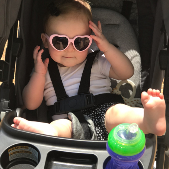 Baby in stroller wearing Just A Shade Smaller® pink rubber heart Baby Love sunglasses