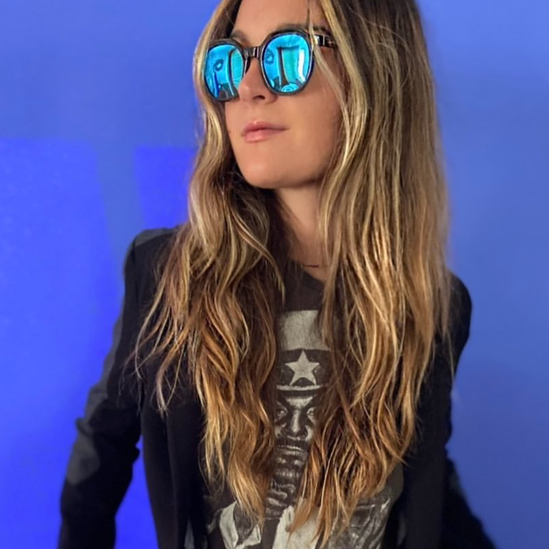 Woman wearing Islander Eyes Grenada polarized sunglasses against a blue background