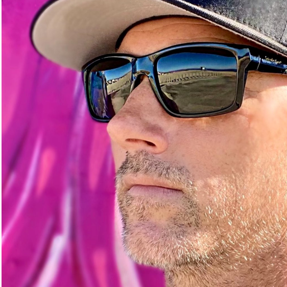 Man wearing Islander Eyes Roatan polarized sunglasses against a pink background